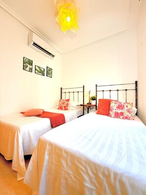 A hotel room with two beds, a ceiling fan, an air conditioning unit, and a wall-mounted artwork. - Casa Ana - Two Bedroom Resort, Sleeps 4 (San Juan de los Terreros)