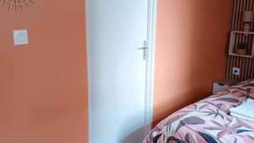 Une chambre à coucher avec un lit, une porte et des éléments de décoration murale.