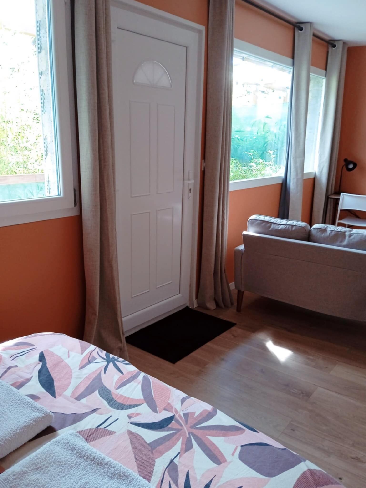 Una stanza con un letto, un divano, una porta e una finestra.