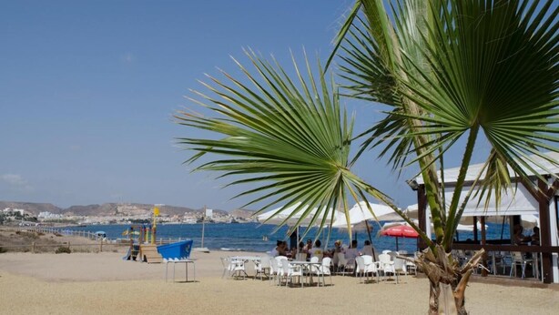 A beachside restaurant with outdoor seating, palm trees, and a view of the sea. - Casa Roberto - Two Bedroom Apartment, Sleeps 4 (Pulpí)