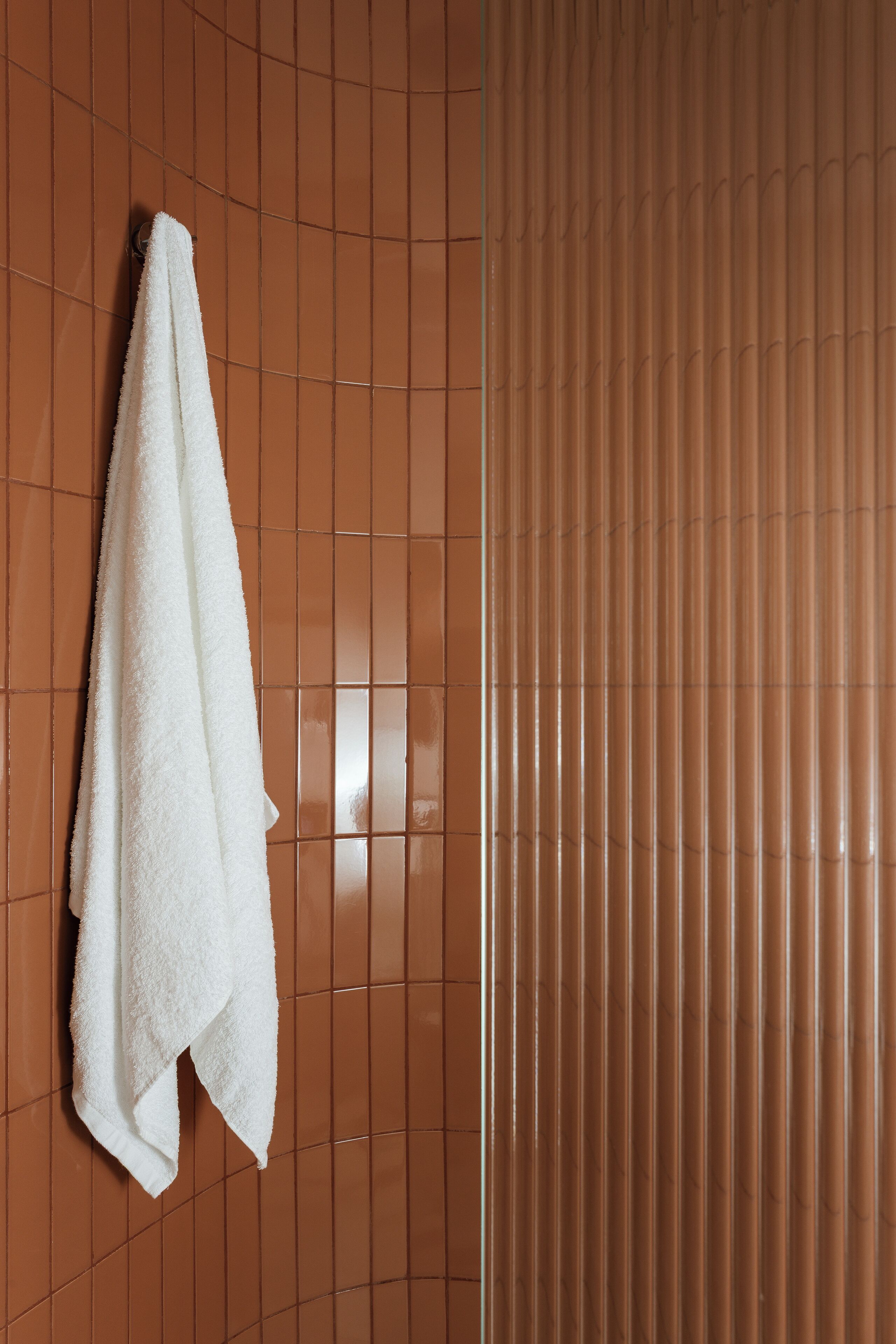 A bathroom with a white towel hanging on a rack.