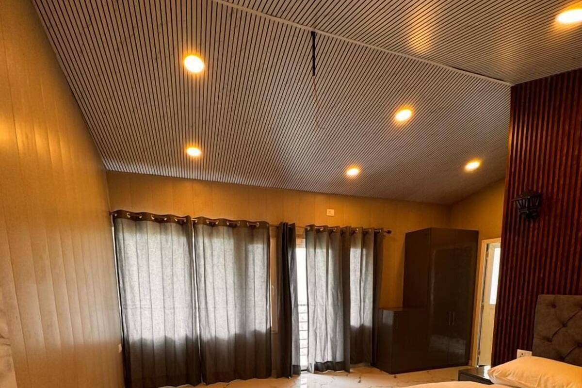 Ein Hotelzimmer mit einem großen Bett, einem Holzschrank, einem Marmorboden und einer Decke mit Rasteroptik.