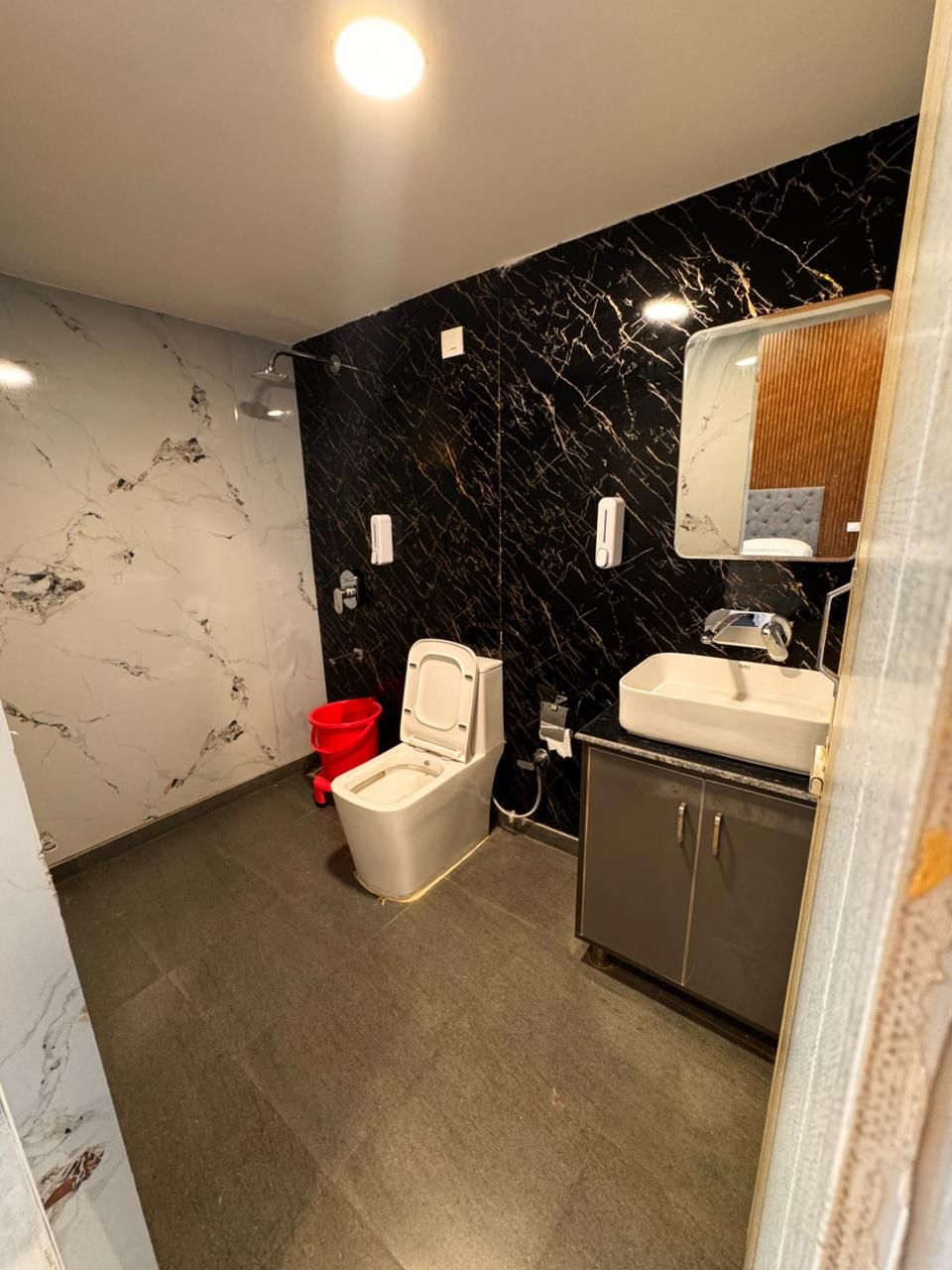 A modern bathroom with a toilet, sink, and mirror.