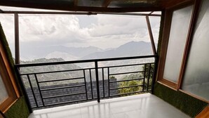 A spacious balcony with a view of distant mountains and a cloudy sky. - The Grand Resort (Dhanaulti)