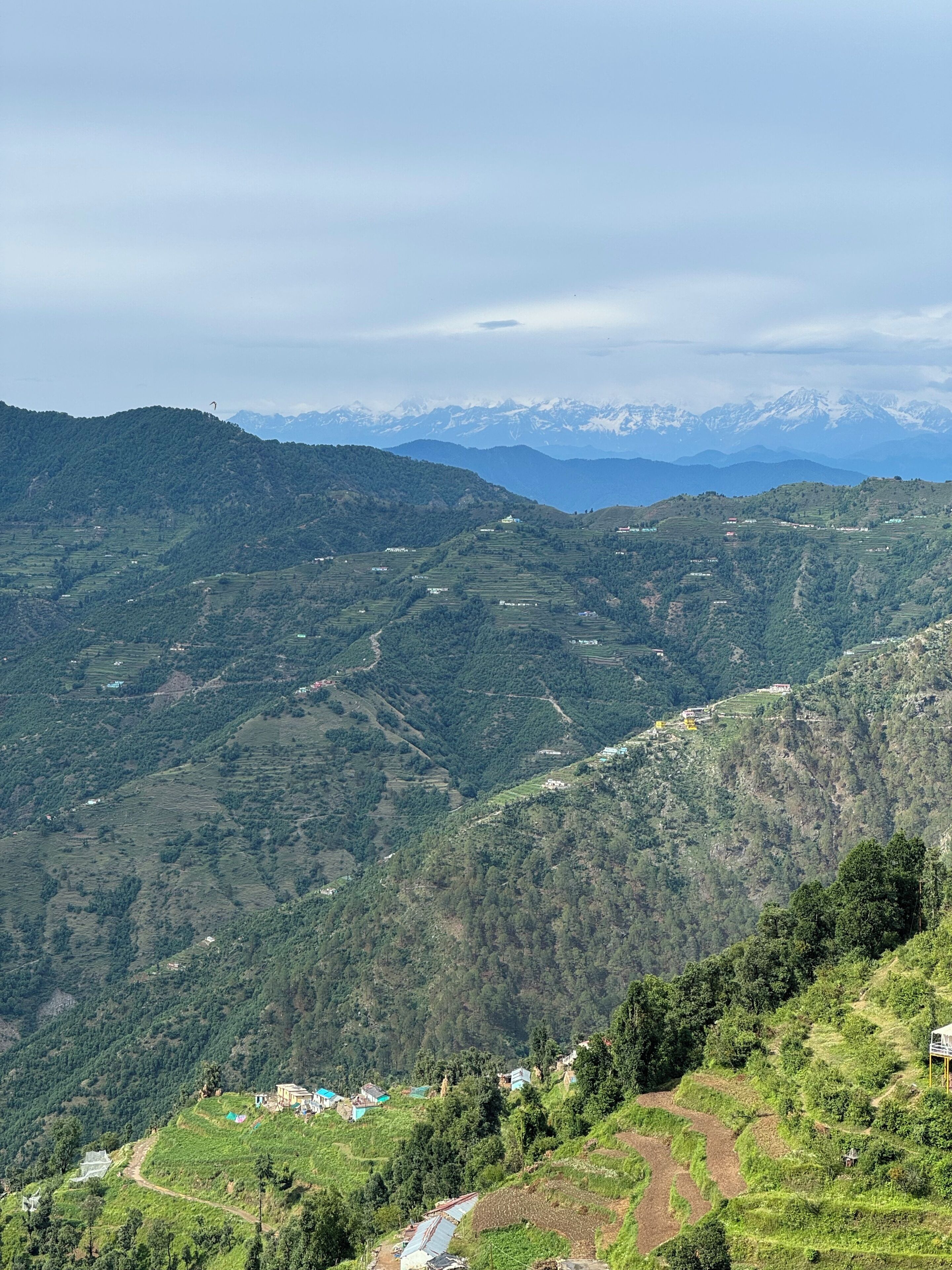 Un paisaje montañoso con campos en terrazas y edificios dispersos.