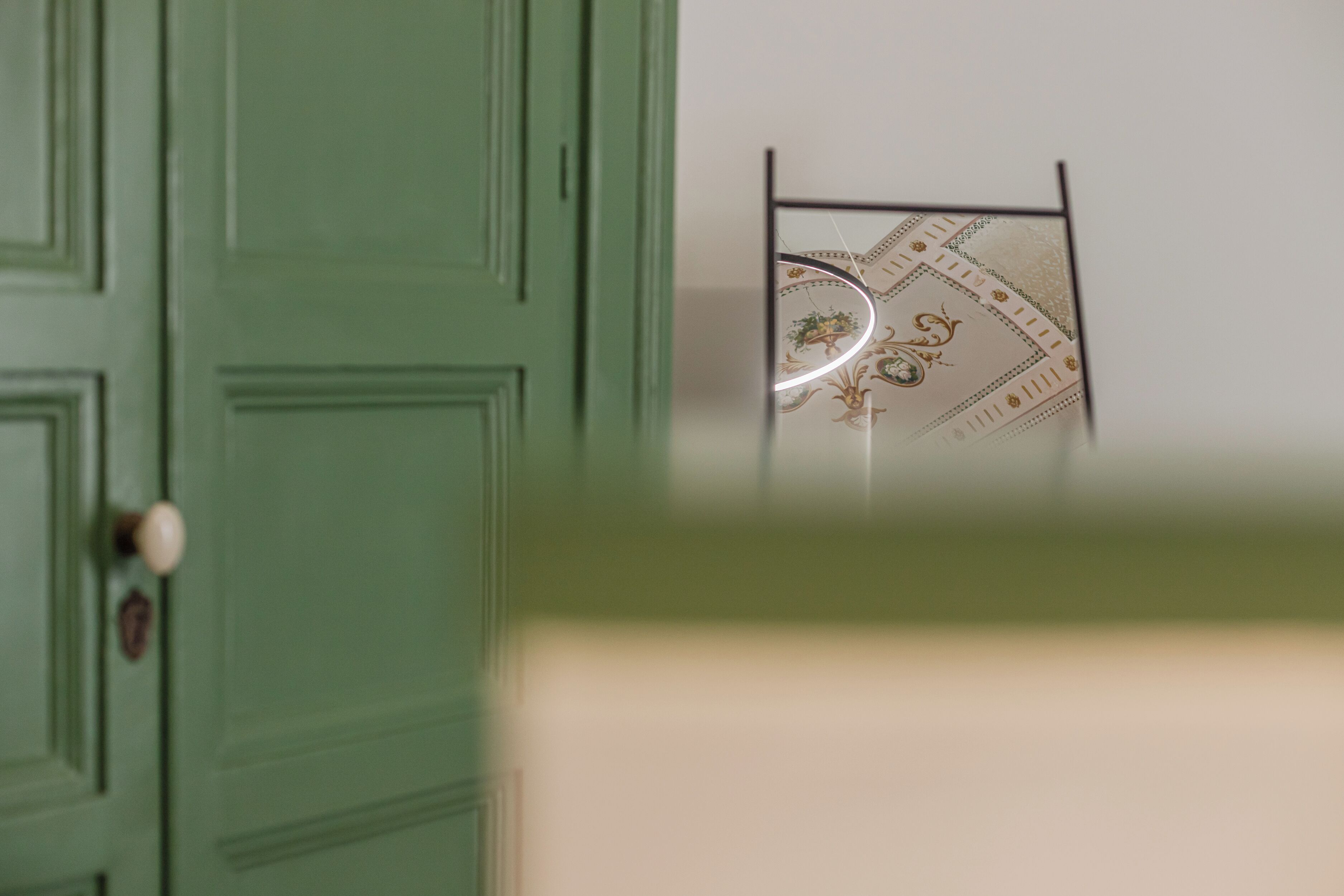Una puerta verde con un pomo redondo y un pequeño emblema.