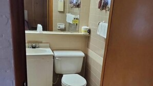 Een kleine badkamer met toilet, wastafel en spiegel.