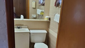 Ein kleines Badezimmer mit Toilette, Waschbecken und Spiegel.