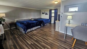 Une chambre avec deux lits, un bureau et une chaise.