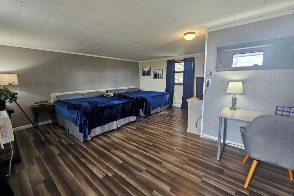 Ett rum med två sängar, ett skrivbord och en stol.