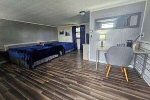 A hotel room with two beds, a desk, a chair, and a mirror. - Deluxe Double Room, 2 Queen Beds #20 (Hart)