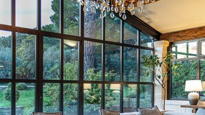 A modern living room with a large sectional sofa, two round coffee tables, and a chandelier. - Luxury Mas in Gordes with pool & view Charming comfort and privacy (Gordes)