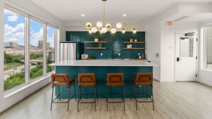 Una cocina moderna con barra, ventanas amplias y vistas a la ciudad.