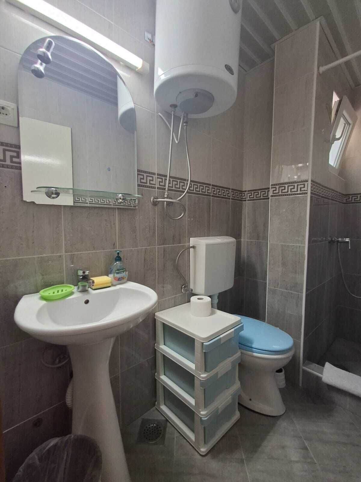 A bathroom with a pedestal sink, toilet, and shower.