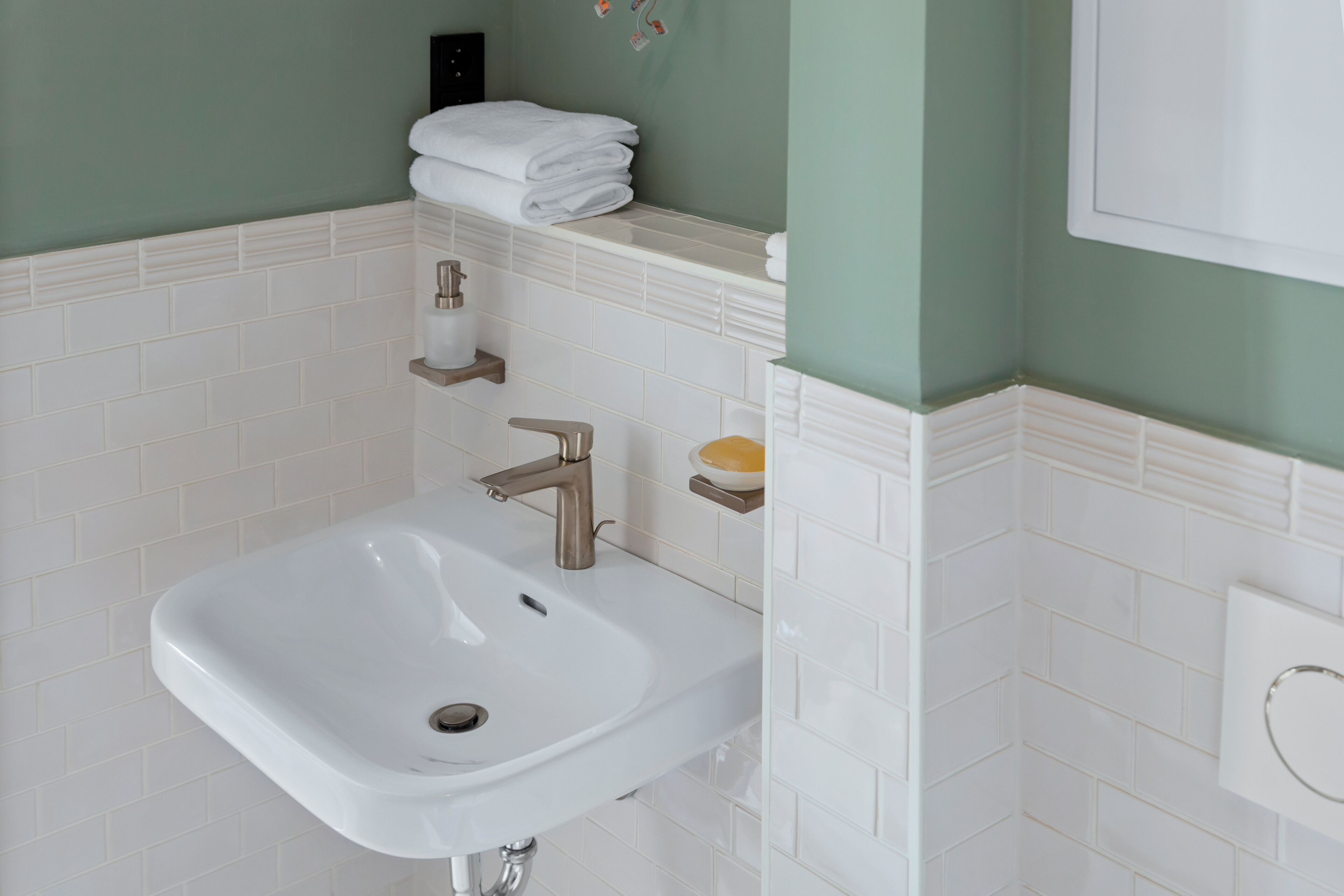 A bathroom with a white sink, a towel rack, and a soap dish.