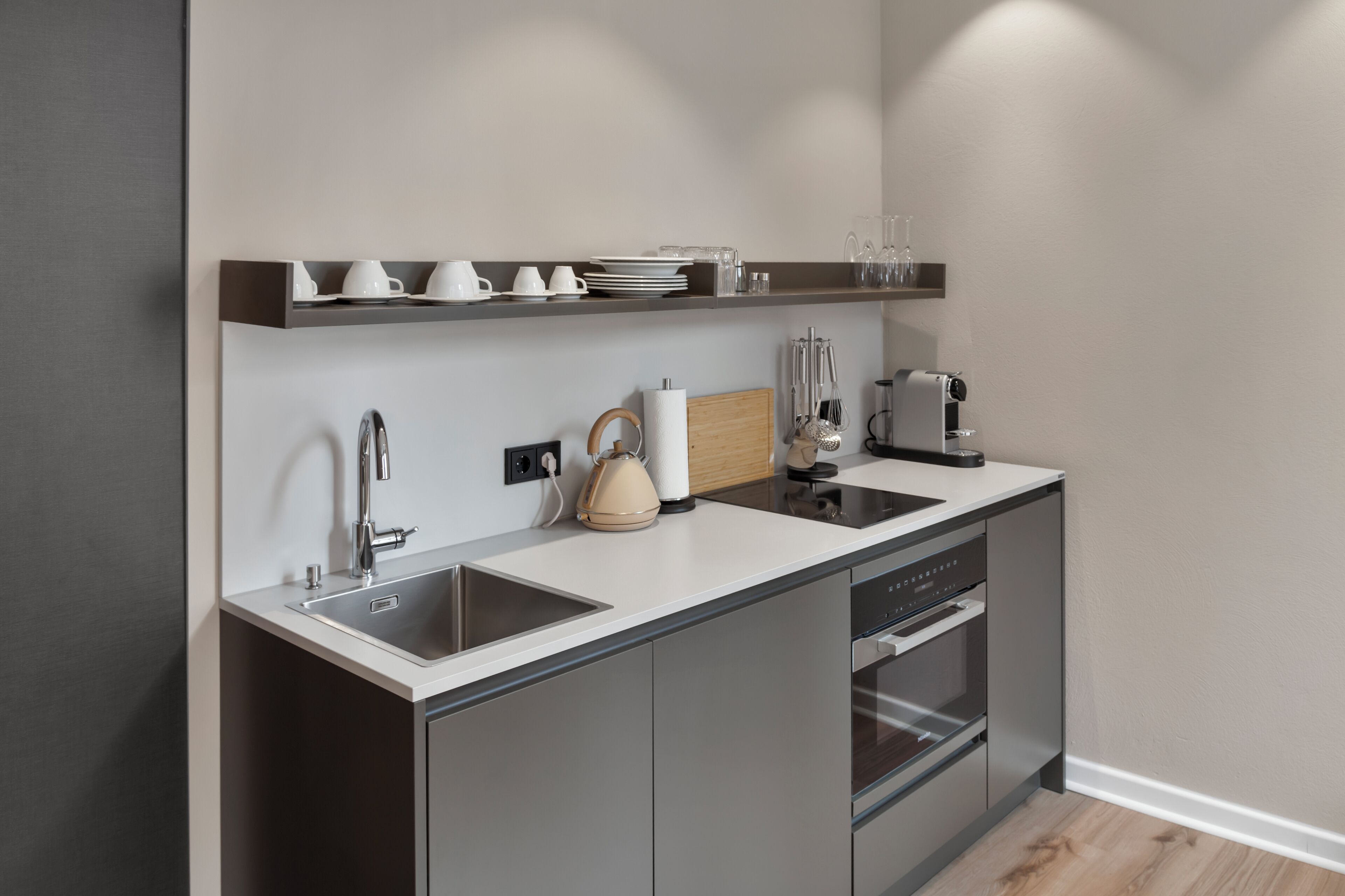 Una cocina moderna equipada con lavavajillas, hervidor y cafetera.