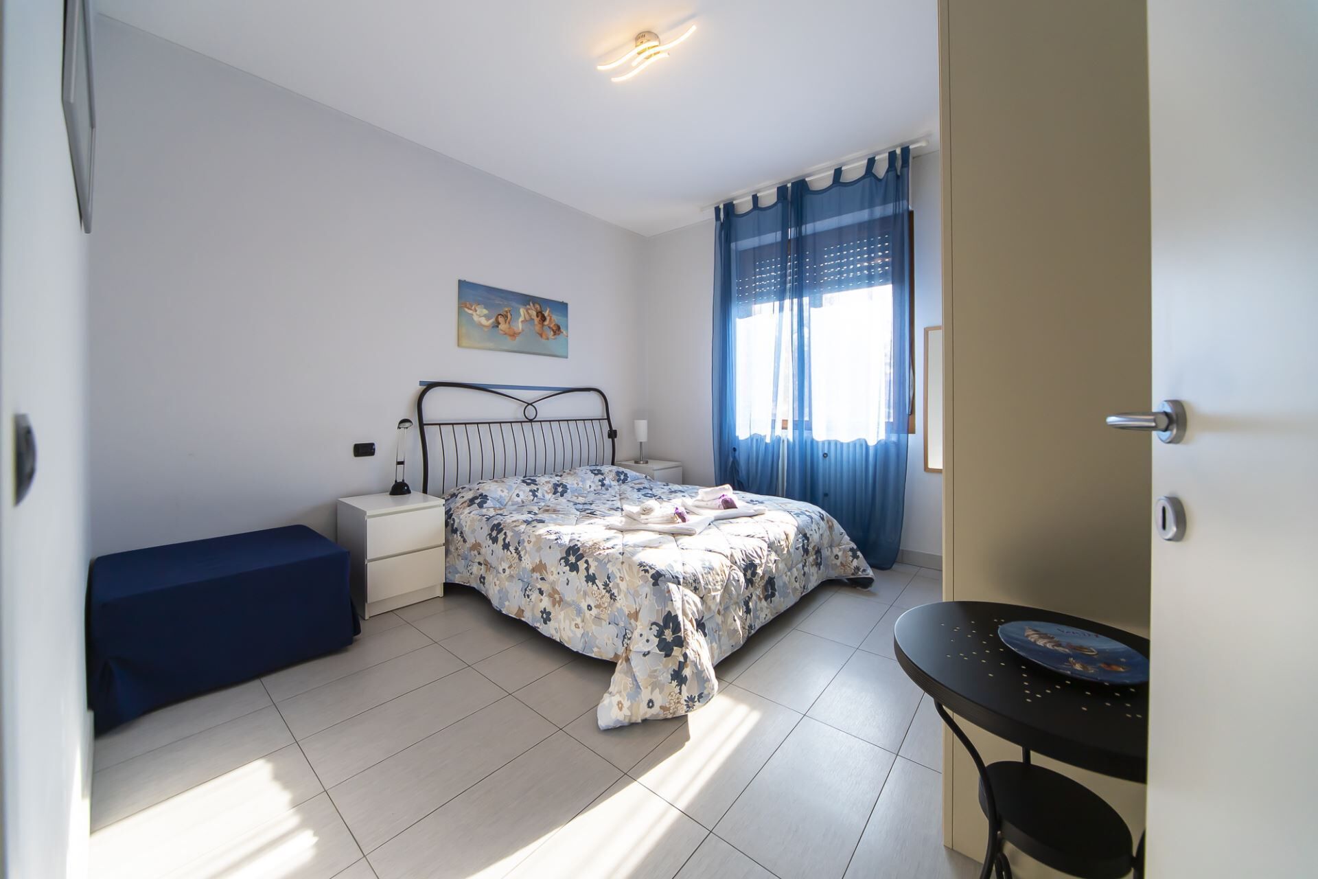 Une chambre à coucher avec un lit, une table de chevet et une petite table sur laquelle se trouve une assiette.