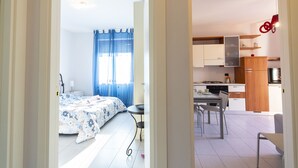 A bedroom with a bed, a nightstand, and a window with blue curtains.