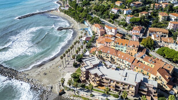 A coastal town with a beach, terraced houses, and a rocky shoreline.