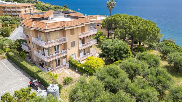 A multi-story building with balconies overlooking a coastal area.
