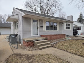 A single-story house with a front porch, a garage, and a brick foundation. - Fully updated 3-bedroom home near college and hospitals. (Sioux City)