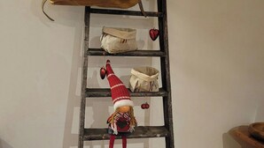 Una escalera de madera rústica con una muñeca y una bolsa de nueces al pie.