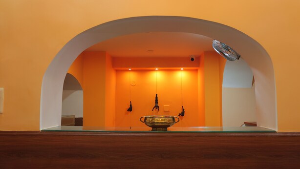A reception area with a wooden reception desk, a glass-top table, and a large decorative bowl.