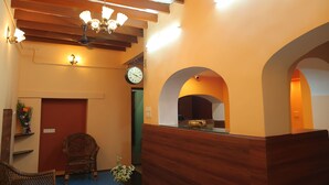 A reception area with a wooden reception desk, a clock, and a chandelier.