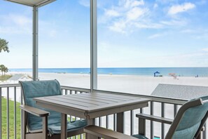 A covered outdoor seating area with a view of the beach. - Condo 206 - Premium - Your Beachfront Retreat Awaits (Sarasota)