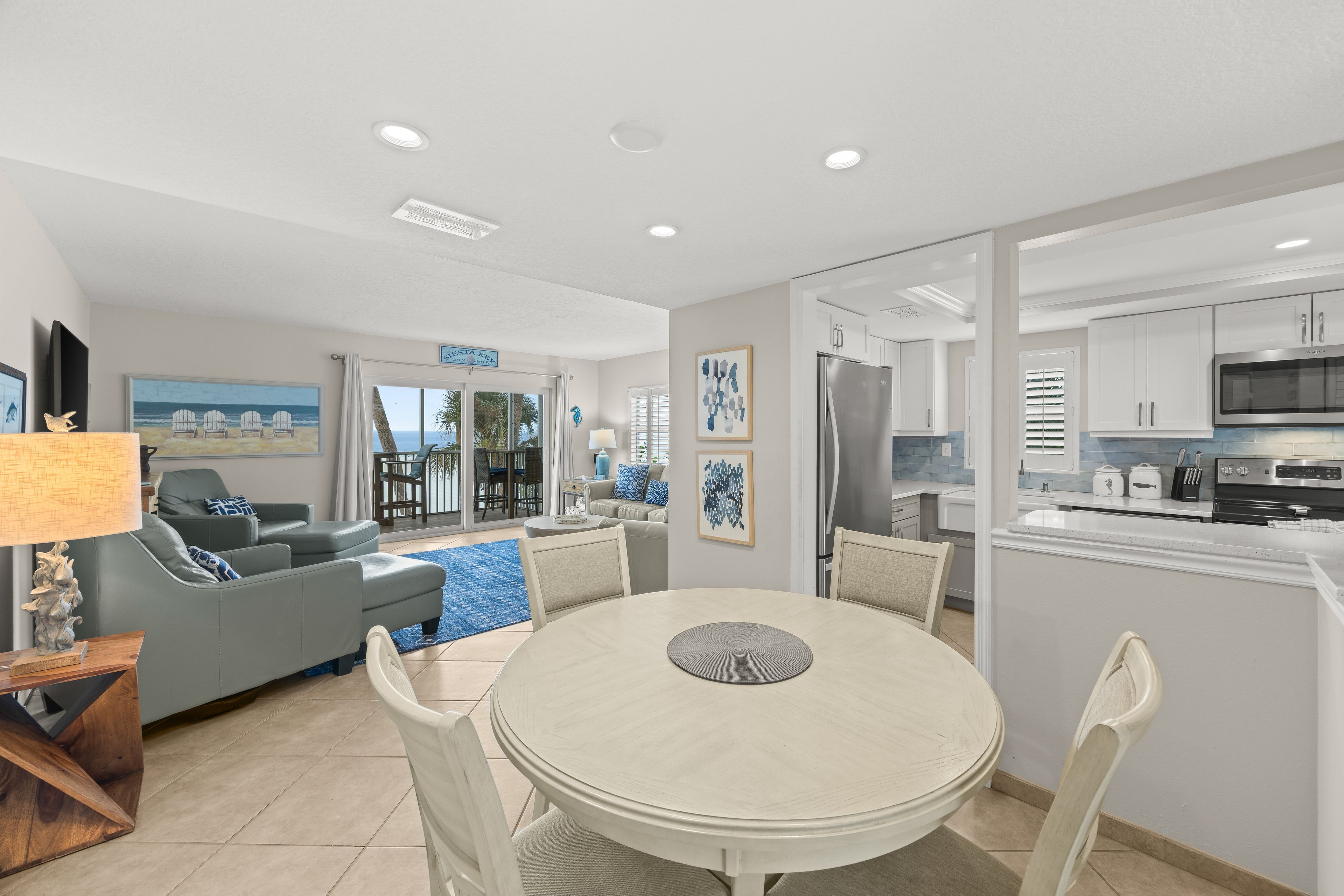 A modern kitchen with white cabinets, a stainless steel refrigerator, and a microwave.