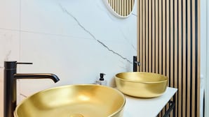 A bathroom with two gold sinks, a marble wall, and a wooden slat wall. - Hedera Estate, Hedera A54 (Mlini)