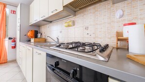 A kitchen with a gas stove, oven, and cabinets. - Apartment 'Casetta Bella' with Balcony, Wi-Fi and Air Conditioning (Condrò)