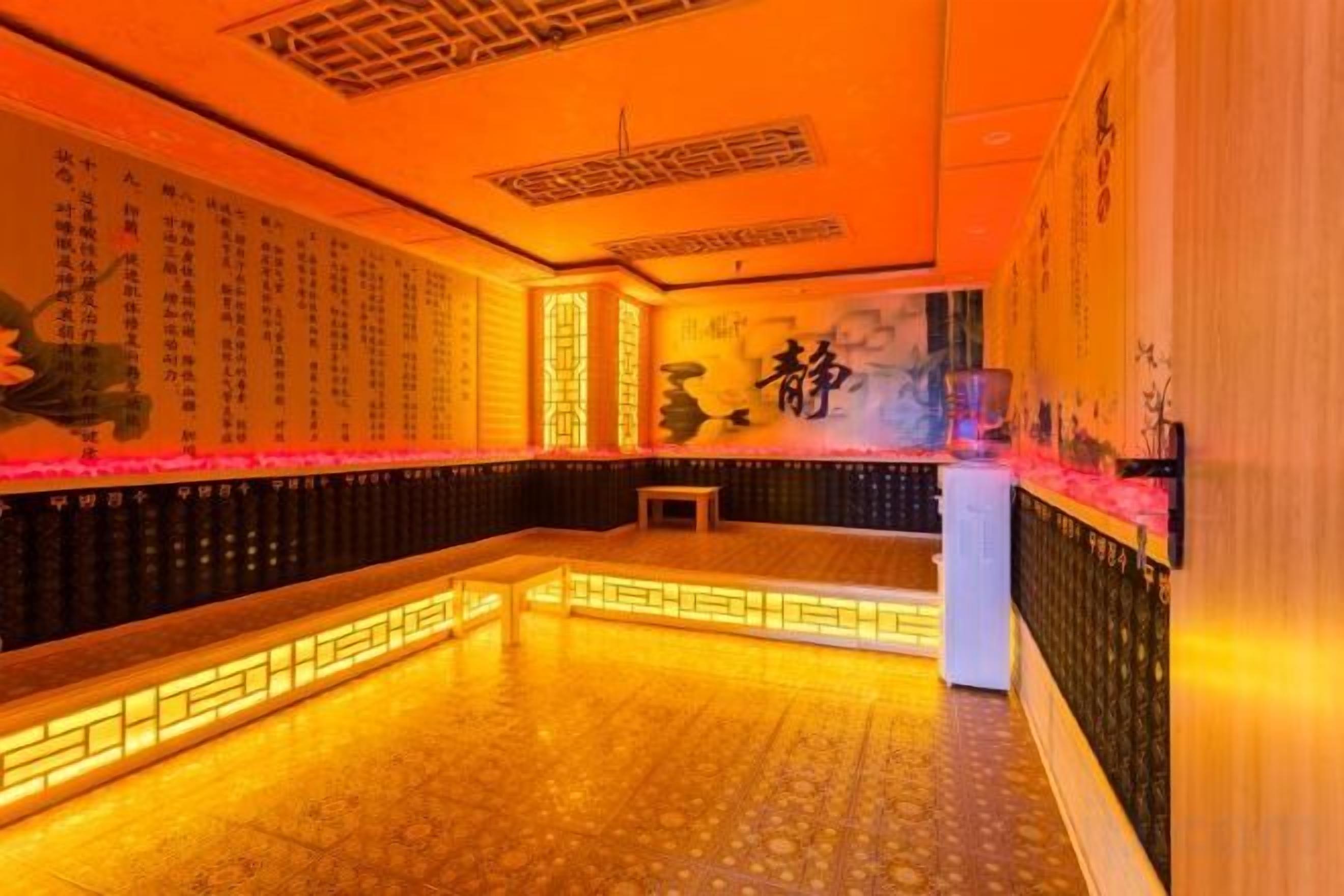 A room with a traditional design, featuring a long bench along the wall and a small table in the center.
