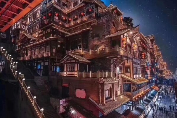 Um edifício de vários andares com arquitetura tradicional, apresentando varandas e uma escadaria que leva aos níveis superiores.