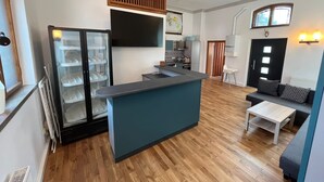 A compact living space with a kitchenette, a seating area with a sofa and coffee table, and a small dining table. - Former church in new splendor (Oranienbaum-Wörlitz)