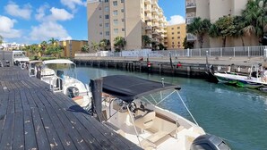 A marina with boats docked, a wooden deck, and buildings in the background. - Luxury RiverFront by Renzzi (Miami)