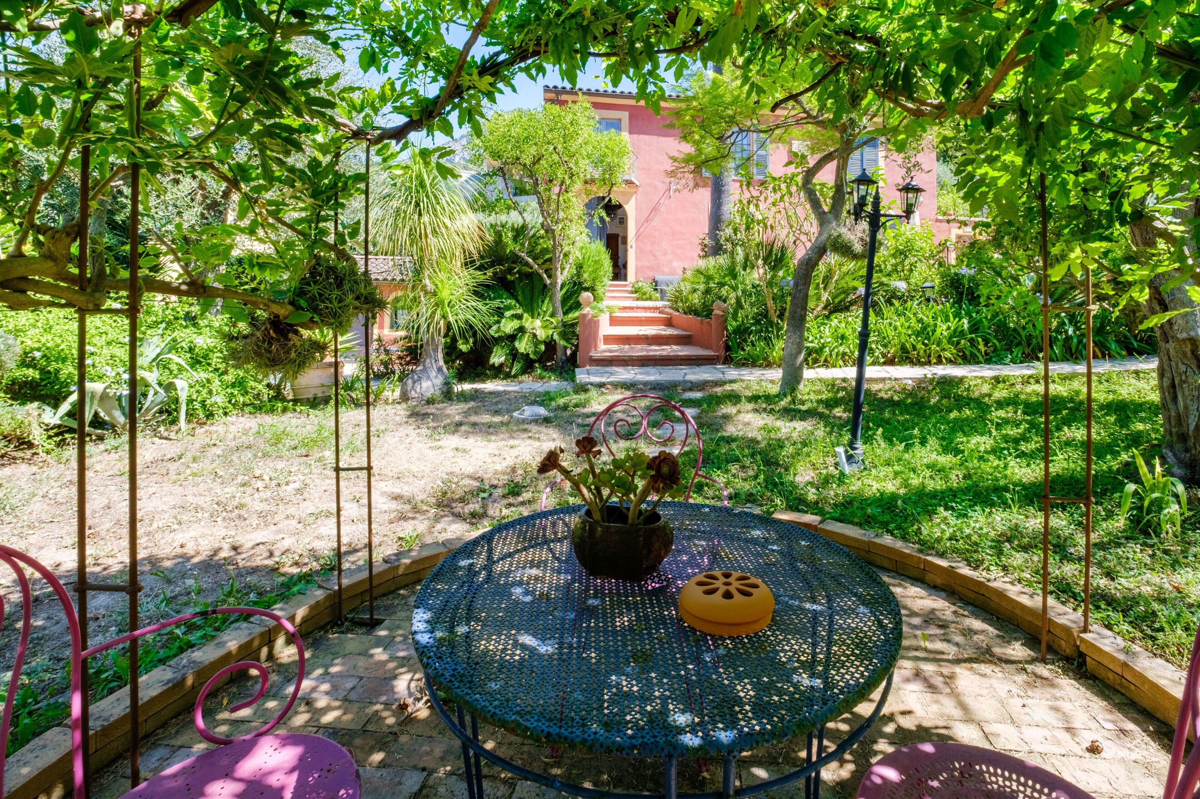 Eine Gartenpatio mit einem runden Metalltisch, einem Blumentopf und einem gelben Gegenstand auf dem Tisch.