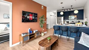 A modern living room with a Netflix TV, a wooden coffee table, and a sofa.