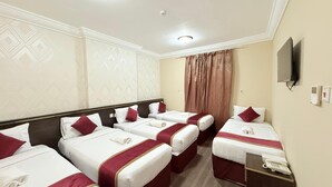 A hotel room with four single beds, a TV, a telephone, and a minibar. - Wifaq Alnuzhah Hotel (Makkah)