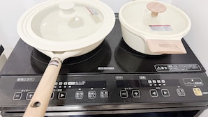 An IRIS OHYAMA electric stove with two pots and a pan.