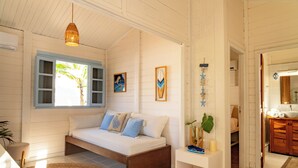 A bedroom with a bed, a bedside table, a window, and a door leading to a bathroom. - Flow House Jeri (Jijoca de Jericoacoara)