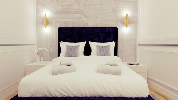 Una cama bien hecha con sábanas blancas y dos almohadas, flanqueada por dos mesitas de noche con lámparas, en una habitación con un diseño arquitectónico clásico.