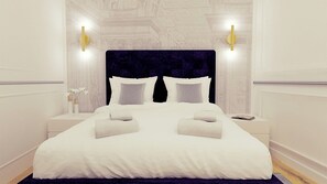 A neatly made bed with white linens and two pillows, flanked by two bedside tables with lamps, in a room with a classic architectural design. - In the heart of Rome, two minutes from Piazza Navona, you'll find Apartament Leutari (Roma)