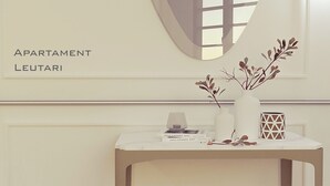 Una habitación minimalista con una mesa que muestra libros, un jarrón con ramas y un recipiente geométrico.
