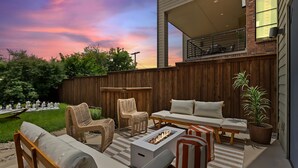 A patio with outdoor furniture, a fire pit, and a view of the sunset. - Ultimate Group Getaway - Twin Lofts - Sleeps 20 (Dallas)