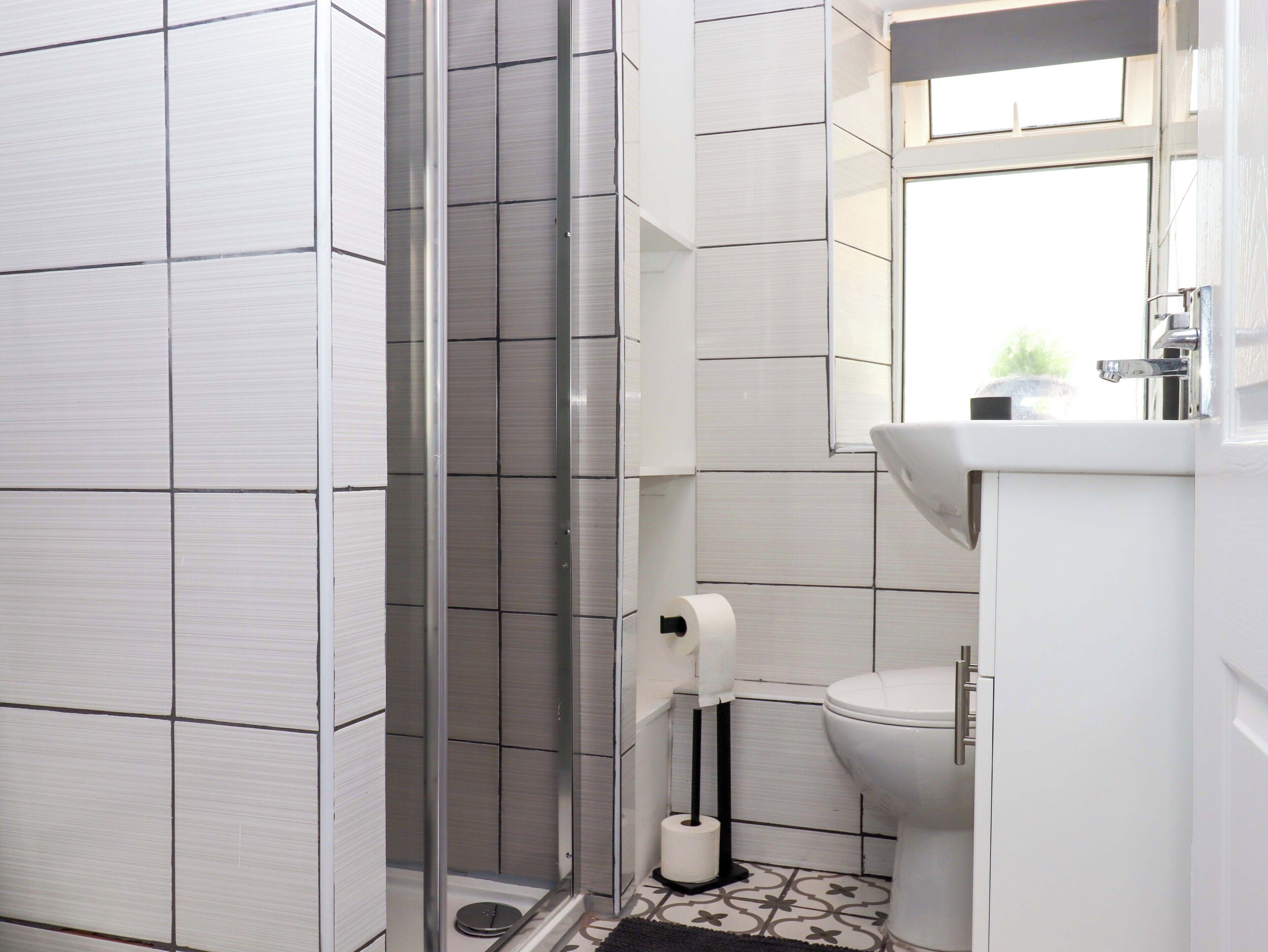 A modern bathroom with a shower, toilet, and sink.