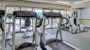 Et træningscenter med løbebånd, crosstrainere og en motionscykel.