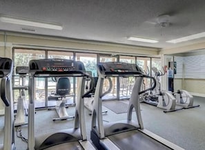 A gym with treadmills, ellipticals, and a stationary bike.