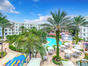 A hotel with a swimming pool, outdoor seating, and palm trees. - spacious pet friendly (Kissimmee)