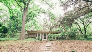 Un sentier menant à un bâtiment rustique, entouré d’arbres.